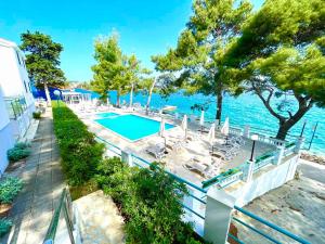 a house with a swimming pool next to the water at Apartment A2 - Prvi zal in Lumbarda