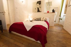una camera con un letto con una coperta rossa e bianca di Antiche Mura ad Arezzo