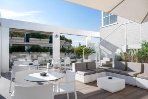 a patio with couches and tables on a building at Dan Hotel in Riccione