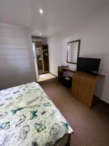 a bedroom with a bed and a desk and a mirror at Casa Eva in 2 Mai