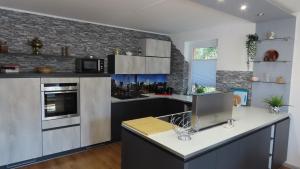 a kitchen with stainless steel appliances and a brick wall at Ferienhaus Sava in Garz