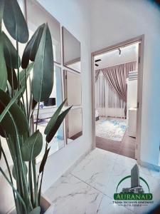 ein Zimmer mit einer Topfpflanze vor einer Tür in der Unterkunft AuranadTroikaKB Apartment Wifi-Netflix-Coway in Kota Bharu