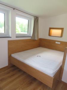 - un lit dans une chambre avec 2 fenêtres dans l'établissement Ferienwohnung Eisl 2, à Sankt Wolfgang im Salzkammergut