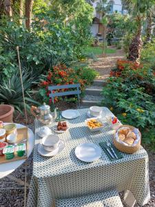 a picnic table with food on it in a garden at La villa des Amandiers in Hyères