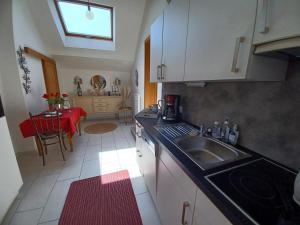 una cocina con fregadero y mesa. en Gite avec SPA privé, en Drulingen