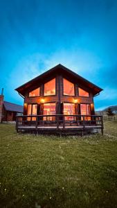 a large log cabin in a field of grass at Sirnea Chalet in Şirnea