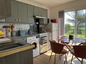 cocina con fregadero y mesa con sillas en VALLEY VIEW self-catering coastal bungalow in rural West Wight, en Freshwater