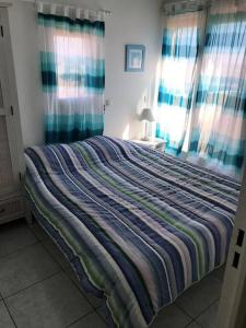 un grande letto in una camera da letto con tende di Appartement T3 climatisé avec vue sur mer a Fleury