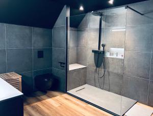 La salle de bains est pourvue d'une douche avec une porte en verre. dans l'établissement Mystic House, une escapade romantique et glamour, à Quatzenheim