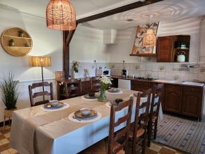 a kitchen with a table and some chairs and a kitchen with at Le Clos Loret in Saint-Germain-du-Corbéis
