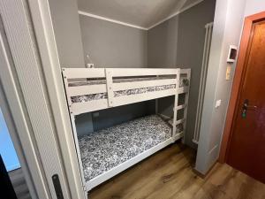 ein weißes Etagenbett in einem kleinen Zimmer in der Unterkunft Relax in montagna in Bardonecchia