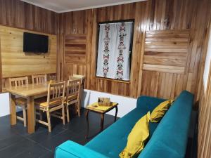 a living room with a blue couch and a table at Apartman Djokovic in Žabljak +6 photos