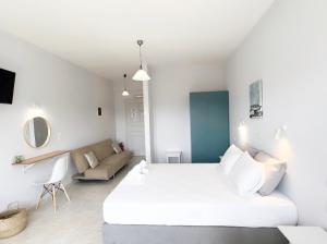 フィニクーダにあるIlias Apartmentsの白いベッドルーム(ベッド1台、ソファ付)