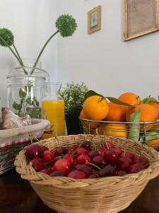 una cesta de cerezas y naranjas sobre una mesa en Donna Elena, en Vico del Gargano