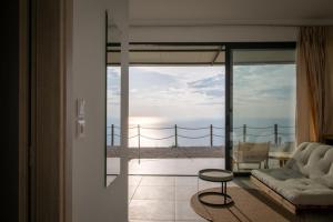 a living room with a couch and a view of the ocean at SECRET HILL in Athani