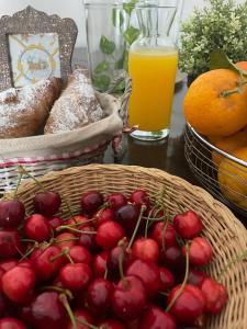una mesa con una cesta de cerezas y un vaso de zumo de naranja en Donna Elena, en Vico del Gargano