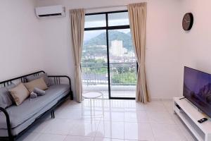 a living room with a couch and a large window at TheSun #Studio #BayanLepas #Pisa in Kampong Manggis