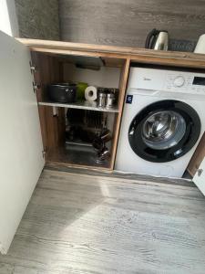 a kitchen with a washing machine in a cabinet at ЛЮКС однокомнатная квартира. ЦЕНТР. in Balqash