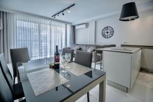 una cucina e una sala da pranzo con tavolo e bicchieri da vino di Seaside Luxury Apartment a San Pawl il-Baħar
