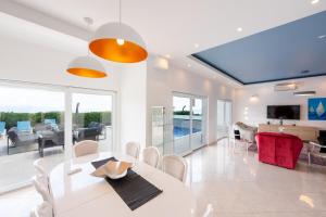 a dining room with a white table and chairs at Villa Sveti Petar - with heated pool and outdoor jacuzzi in Opatija
