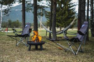 a group of three chairs around a camp fire at Apartman Djokovic in Žabljak