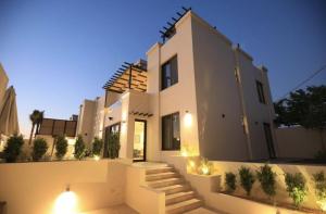 a large white house with stairs and lights at Zerø Føur DeadSea in Sowayma