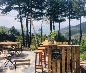 um pátio com uma mesa e cadeiras e montanhas ao fundo em Minds & Mountains Eco Lodge em La Molina