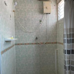 een douche met een slang in de badkamer bij Zappa Guesthouse in Pattaya