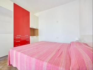 a bedroom with a pink bed and red cabinets at Silvana in Nisporto