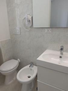 a bathroom with a white toilet and a sink at Mare Luna Apartment in Bari