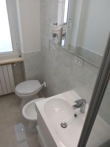a bathroom with a sink and a toilet and a mirror at Mare Luna Apartment in Bari