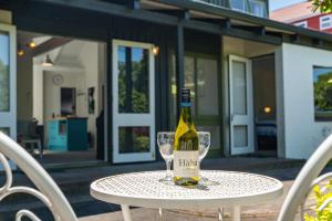 a bottle of wine sitting on a table with glasses at Elegant Townhouse in Taupo