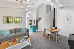 uma sala de estar com um sofá e uma mesa em Elegant Townhouse em Taupo