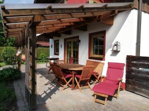 een patio met een houten tafel en stoelen bij Ferienhaus Inntal in Oberaudorf