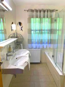 ein Badezimmer mit einem Waschbecken, einer Dusche und einer Badewanne in der Unterkunft Chalet Zauberflöte in Radstadt