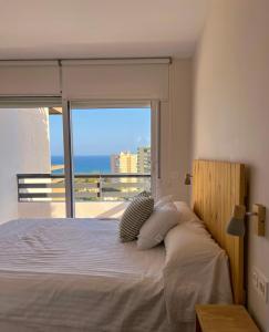 a bedroom with a bed with a view of the ocean at Apartamentos Nogal in Aguadulce