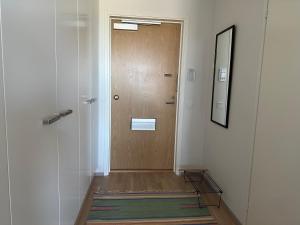 a hallway with a wooden door and a mirror at Near center w/ smart-TV, tram stop and gym visit in Tampere +2 photos
