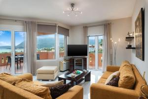 a living room with two couches and a flat screen tv at Villa Androniki in Souda