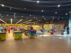 a grocery store aisle with a grocery store with shoppers in it at La Familia Seaside Residence in Salacgrīva