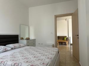 a bedroom with a bed and a dresser and a mirror at Marjana's Apartment 4 in Lezhë