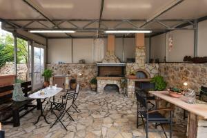a large kitchen with a table and a fireplace at Villa Androniki in Souda