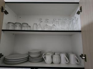 a shelf filled with glasses and plates and bowls at Motebong Villa in Maseru