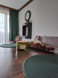 Premium Apartment in Borovets Gardens Complex في بوروفتس: غرفة معيشة مع طاولة مع صينية طعام