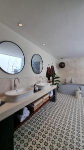 un baño con dos lavabos y dos espejos en VILLA CELAVI 15, en Kerobokan