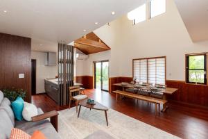 ein Wohnzimmer mit einem Sofa und einer Küche in der Unterkunft LiveGRACE Villa Lake Kawaguchiko 富士河口湖 in Yamanashi