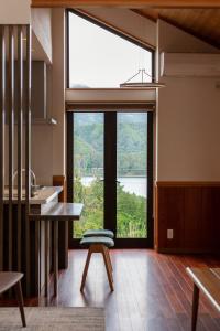 a kitchen with a large window with a table and a stool at LiveGRACE Villa Lake Kawaguchiko 富士河口湖 in Yamanashi