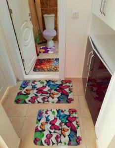 um quarto com três tapetes no chão numa casa de banho em My Home em Beysehir