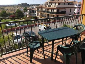d'une table et de chaises sur un balcon avec vue sur la rue. dans l'établissement Apartamento MG, à Huelva