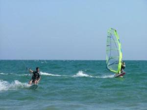 2 personnes sur des planches de surf avec une voile dans l'océan dans l'établissement Apartamento MG, à Huelva