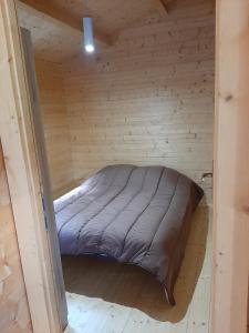 a bed in a wooden room with a wooden floor at Camping Torraccia in Cargèse